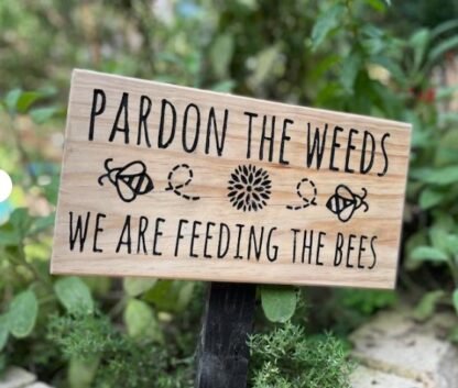 Garden sign pardon the weeds we are feeding the bees